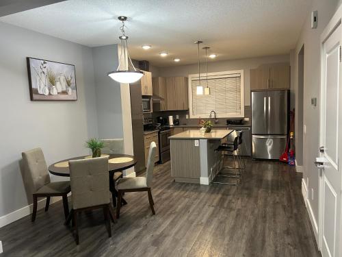 a kitchen and dining room with a table and chairs at Family friendly home at Chappelle garden in Edmonton