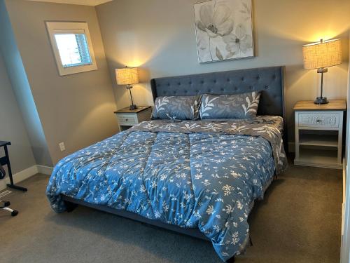 a bedroom with a blue bed with a blue comforter at Family friendly home at Chappelle garden in Edmonton