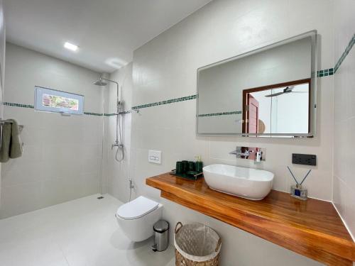 拉威海滩Lotus Bleu Resort & Restaurant的浴室里有洗手池、马桶和镜子。