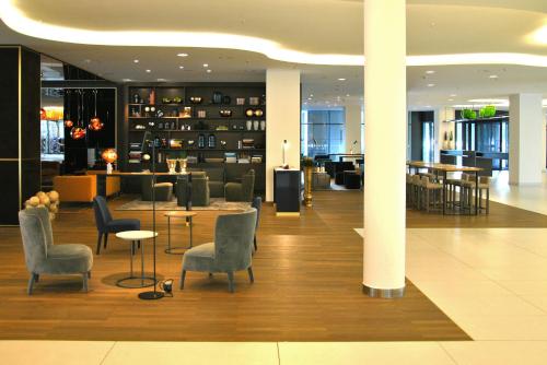 a lobby with chairs and tables in a building at Vienna House by Wyndham Andel's Berlin in Berlin