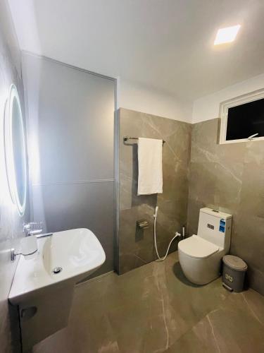a bathroom with a white toilet and a sink at Coco Villa Yala in Tissamaharama