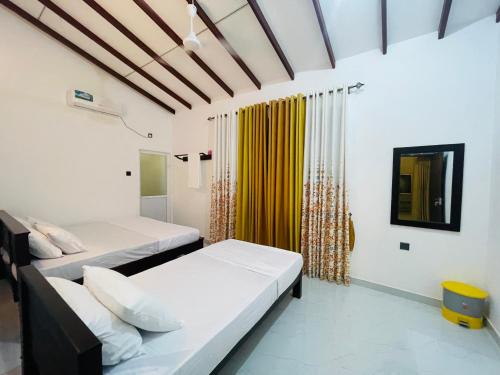 Un dormitorio con dos camas y una ventana. en Coco Villa Yala, en Tissamaharama