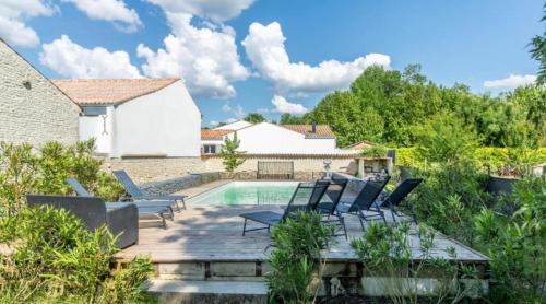 a patio with chairs and a swimming pool at Domaine Ericarclem in Aigrefeuille-dʼAunis