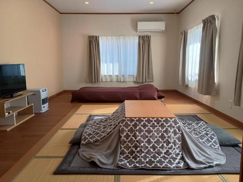 草津町にある草津温泉お宿きみのやのリビングルーム(ベッド1台、薄型テレビ付)