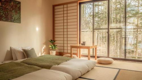 a bedroom with a large bed and a window at 來Lai 北軽井沢Resort Villa 158 in Tsumagoi