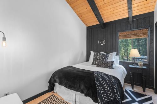 Black Butte RanchにあるShields Shaletのベッドルーム1室(黒い壁のベッド1台、窓付)