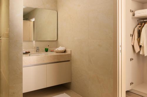 ein Badezimmer mit Waschbecken und Spiegel in der Unterkunft Brassbell l Zamalek l Jeddah Tower in Kairo