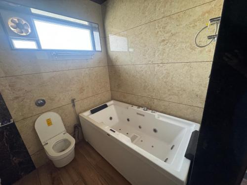 a bathroom with a bath tub and a toilet at NTH Villa in Udaipur