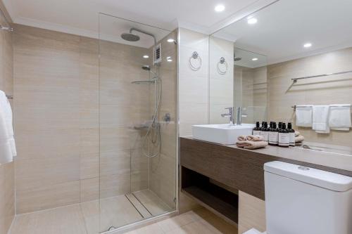 2BR Ground-Floor Gem, Walk to Everything, 2 Pools في ميناء دوغلاس: حمام مع دش ومغسلة ومرحاض