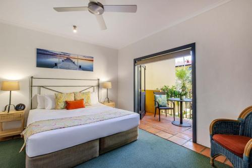 2BR Ground-Floor Gem, Walk to Everything, 2 Pools في ميناء دوغلاس: غرفة نوم بها سرير وباب زجاجي منزلق