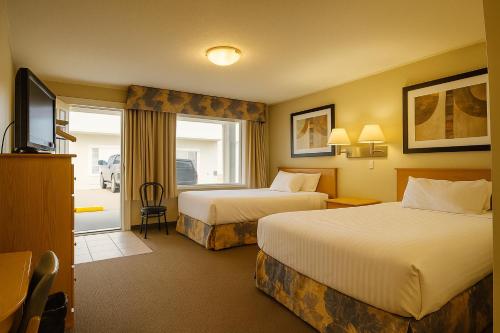 una camera d'albergo con due letti e una televisione di Best Maple Inn - Drayton Valley a Drayton Valley
