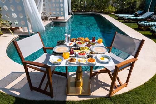 una mesa con desayuno junto a la piscina en The Xon Hotel, en Cesme