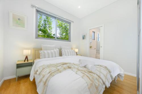 Un dormitorio blanco con una cama grande y una ventana. en Modern Riverwood Home with Parking & Easy Access, en Riverwood