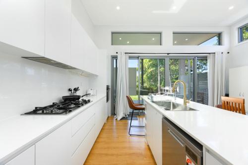 cocina con encimeras blancas y fogones en Modern Riverwood Home with Parking & Easy Access, en Riverwood