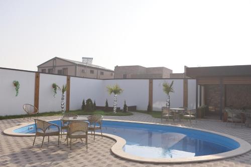 a patio with a table and chairs next to a swimming pool at Davos Hotel in Pʼarakʼar