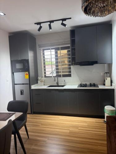 una cucina con armadi neri e piano di lavoro bianco di Decent One Bedroom Apartment at Tantra Hills a Tantra Hill