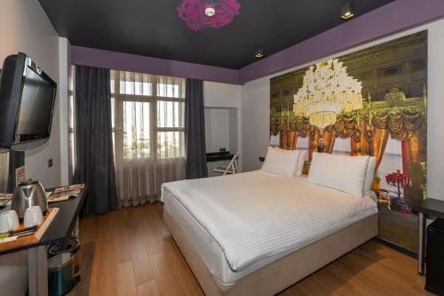 a bedroom with a large white bed and a tv at Tulip City Hotel & SPA in Istanbul