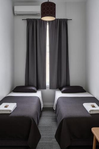 two beds in a room with a window at The Colliefields Hotel in Collie