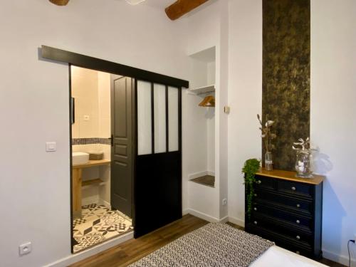 un baño con puerta negra y lavabo en Le Mas, en Saint-Sauveur-de-Cruzières