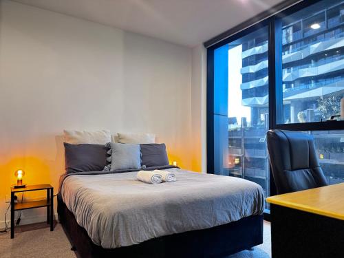 a bedroom with a bed and a desk and a window at 2bedroom city central appletv Homepod pool sauna in Melbourne