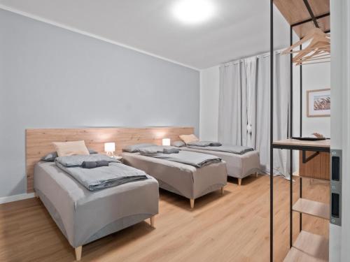 Neueröffnung - Haus Ysenburg - Wohnungen in zentraler Lage في كاسيل: سريرين في غرفة بيضاء مع أرضيات خشبية