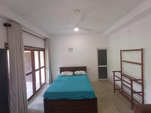 a bedroom with a bed with a blue comforter at Villa diamond nest in Unawatuna