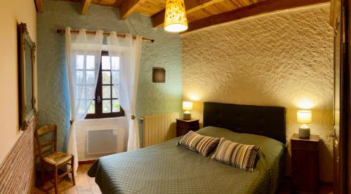 un dormitorio con una cama en una habitación con ventana en Le Mas, en Saint-Sauveur-de-Cruzières
