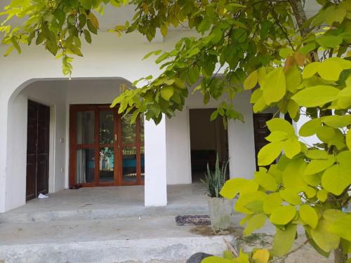 an entrance to a house with a door and a tree at Villa diamond nest in Unawatuna