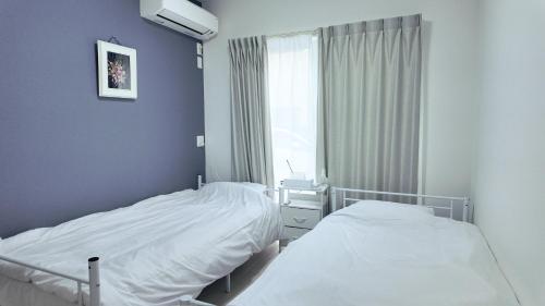 two beds in a room with a window at 嘉翔の家 in Otsu