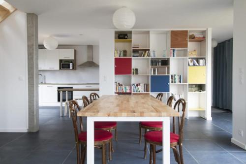 a kitchen and dining room with a wooden table and chairs at Jolie maison neuve PMR au port de l'Aberwrac'h in Landéda