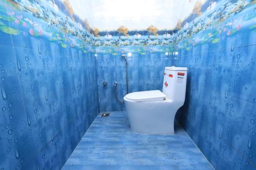 Arun Auro Residency في Kuilapayam: حمام أزرق مع مرحاض أبيض بداخله