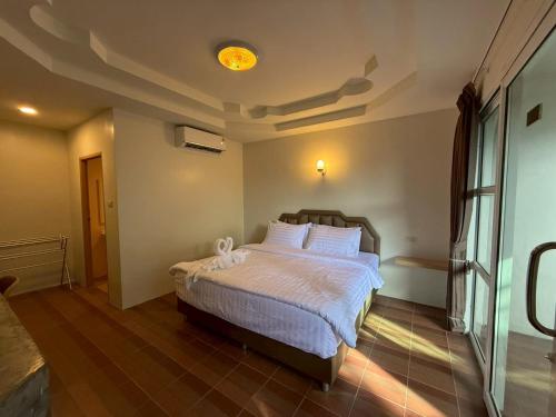 a bedroom with a bed with a white comforter at HUG PHIPHI Resort in Phi Phi Islands