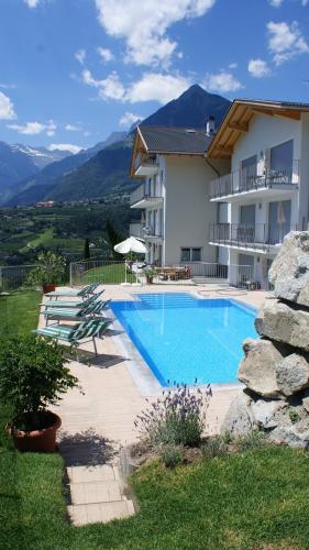 a house with a swimming pool next to a building at Residence Fiegl in Schenna
