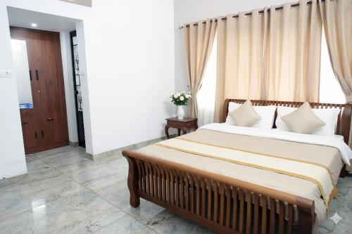 sypialnia z łóżkiem i dużym oknem w obiekcie PATHIRAMANAL Service Villas w mieście Alleppey