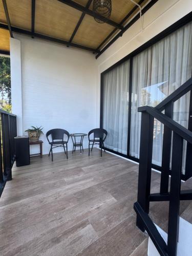 a room with chairs and a table on a balcony at Chaota Modern House in Ban Ao Makham