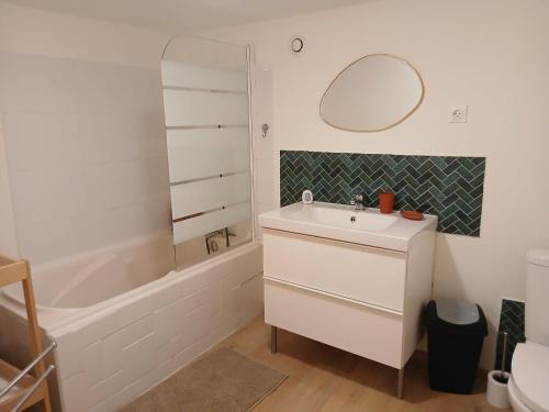 a bathroom with a sink and a tub and a mirror at Ma Maison Vigneronne in Loches