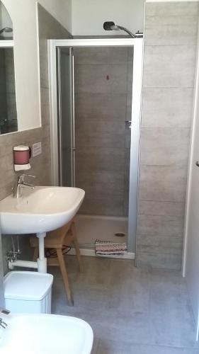 ein Bad mit einem Waschbecken und einer Dusche mit einem Waschbecken in der Unterkunft Agriturismo Zertin in Gravedona
