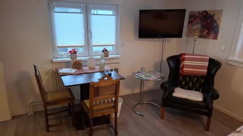 una habitación con un escritorio y una silla y un televisor en Entspannung in Hasselborn, en Waldsolms