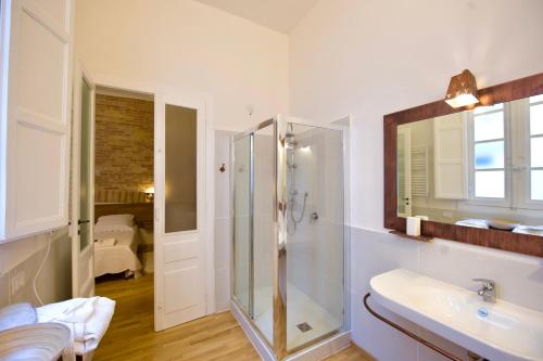 Un baño con ducha de cristal y lavabo. en Castelletto Suites, en Cagliari