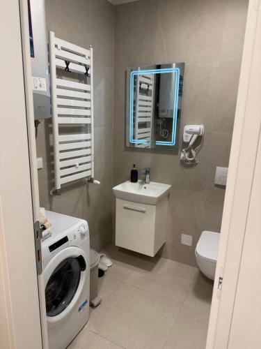 a bathroom with a washing machine and a washer at Delta SPA Residence in Niš