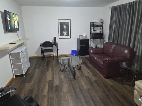 een woonkamer met een leren bank en een glazen tafel bij Bujaks in Inuvik