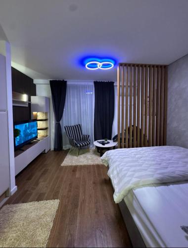a bedroom with a large bed and a blue light at Delta SPA Residence in Niš