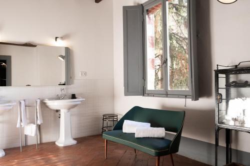 łazienka z zielonym krzesłem i umywalką w obiekcie La Locanda di Grazzano Visconti w mieście Grazzano Visconti
