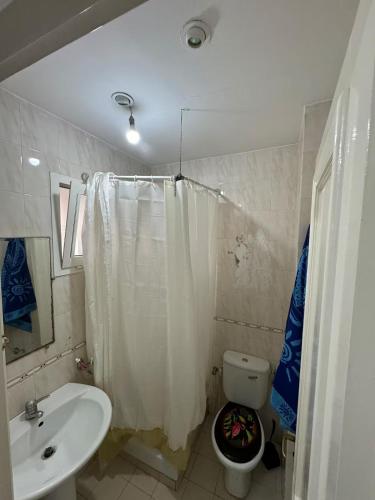 a bathroom with a sink and a toilet with a shower curtain at jawhara residency front view in Sousse