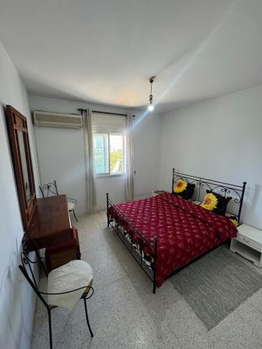 a bedroom with a red bed and a chair at jawhara residency front view in Sousse