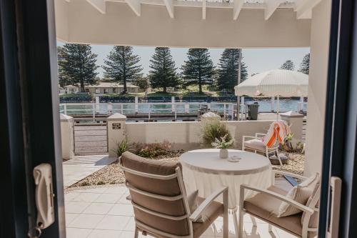 a patio with a table and chairs on a balcony at The Waterfront Apartment in Port Fairy
