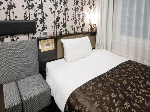 a hotel room with two beds and a chair at APA Hotel Shinagawa Togoshi Ekimae in Tokyo