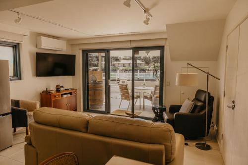 a living room with a couch and a table with chairs at The Waterfront Apartment in Port Fairy