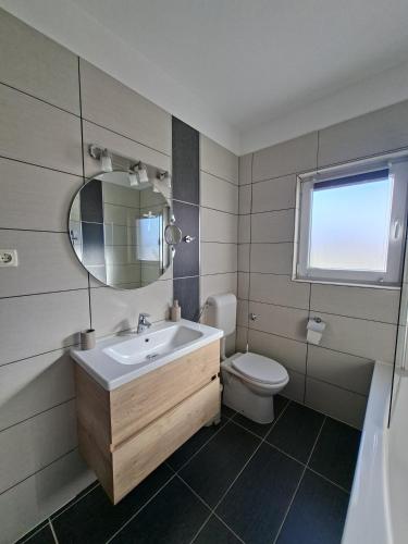 ein Badezimmer mit Waschbecken, Toilette und Spiegel in der Unterkunft MaMio in Šibenik