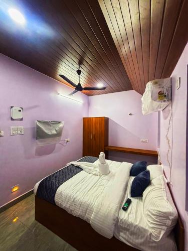 a bedroom with a large bed with a wooden ceiling at le hut residency in Pūrnānkuppam
